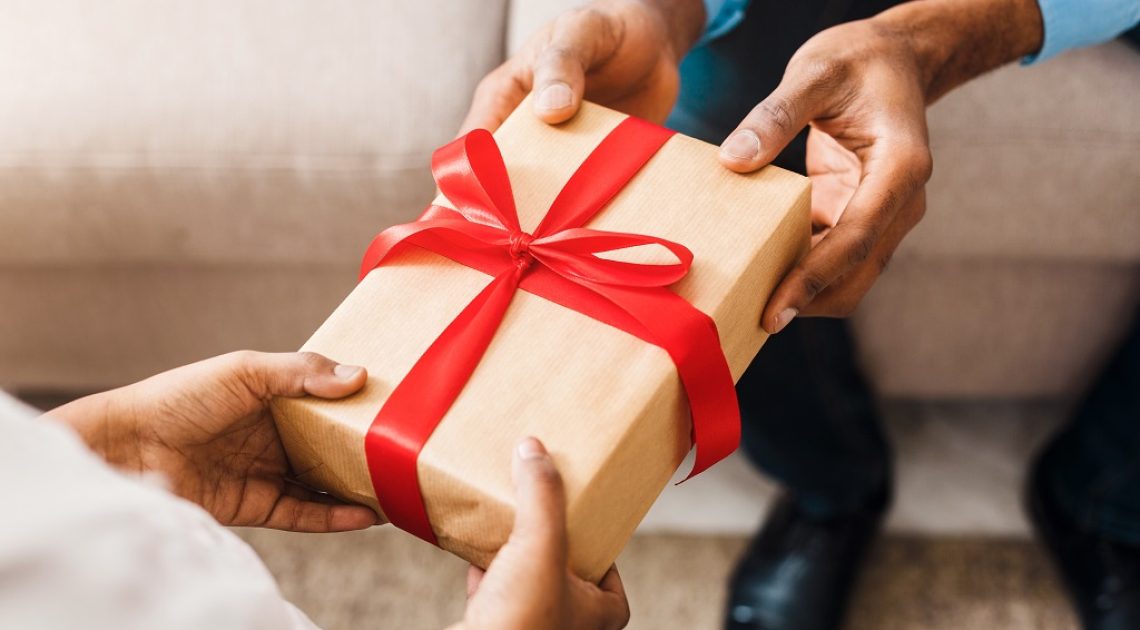 Birthday present. Father giving gift to daughter, closeup